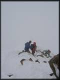 Blick vom etwas ausgesetzten Gipfelgrat der Wildspitze ins nebelige Nichts sowie auf ein paar absteigende Bergkameraden 